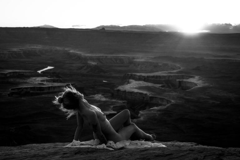 A nude woman arches her back above the white rim trail