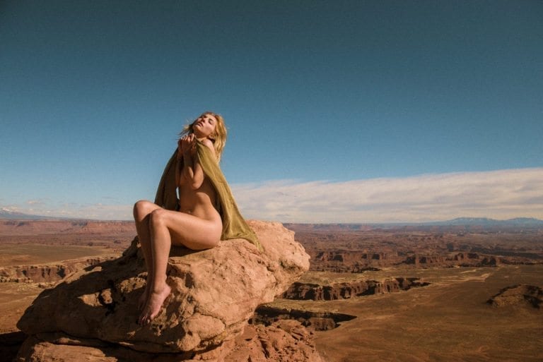 Grace Nielson poses on a rock, high above the canyon country below