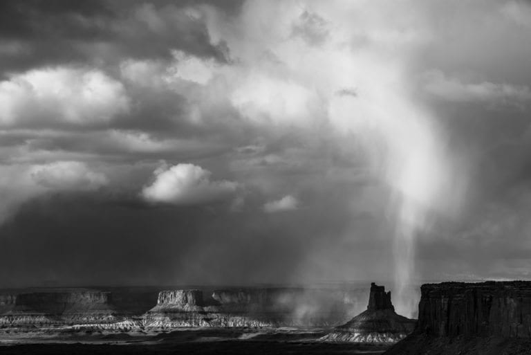 Snow streaks down behind Candlestick butte in Canyonlands National Park