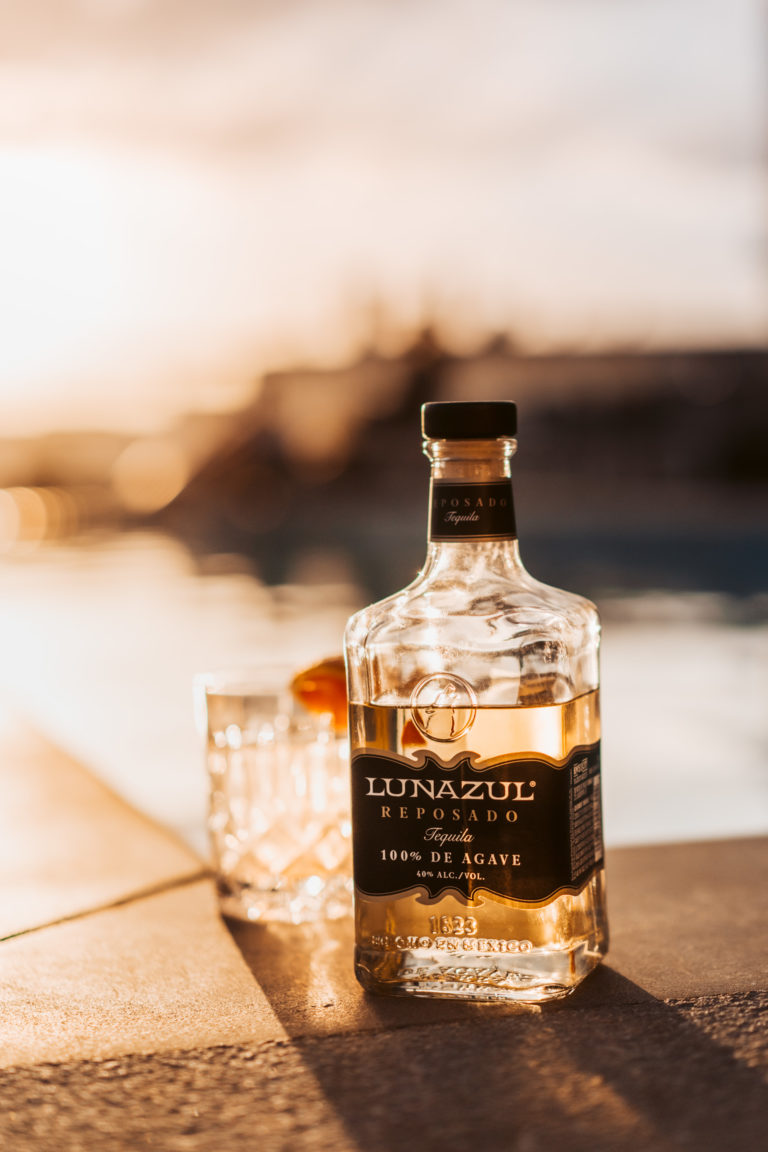 Lunazul tequila back lit on a ledge.