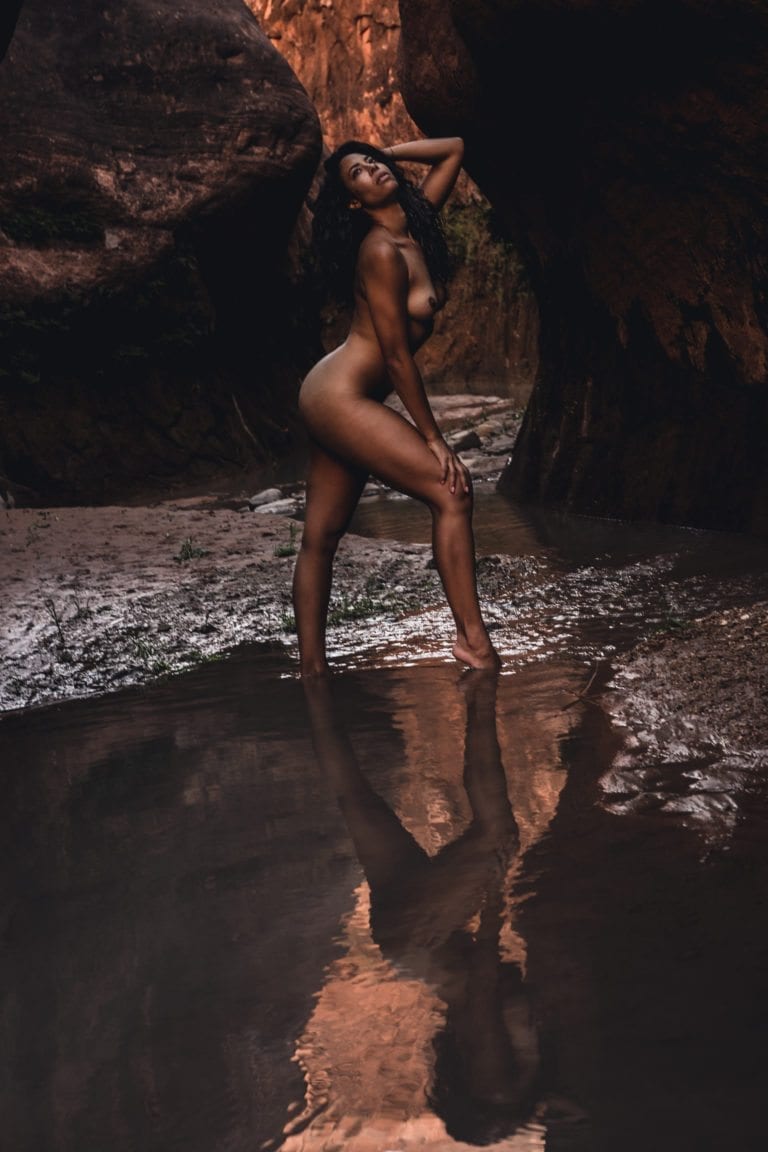 A black woman poses in the ambient light of a southern Utah slot canyon