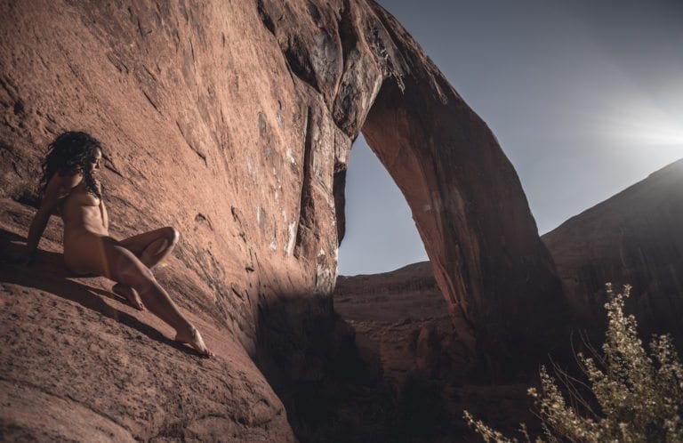 A woman stretches nude under Broken Bow Arch for Dylan H Brown's impermanence series
