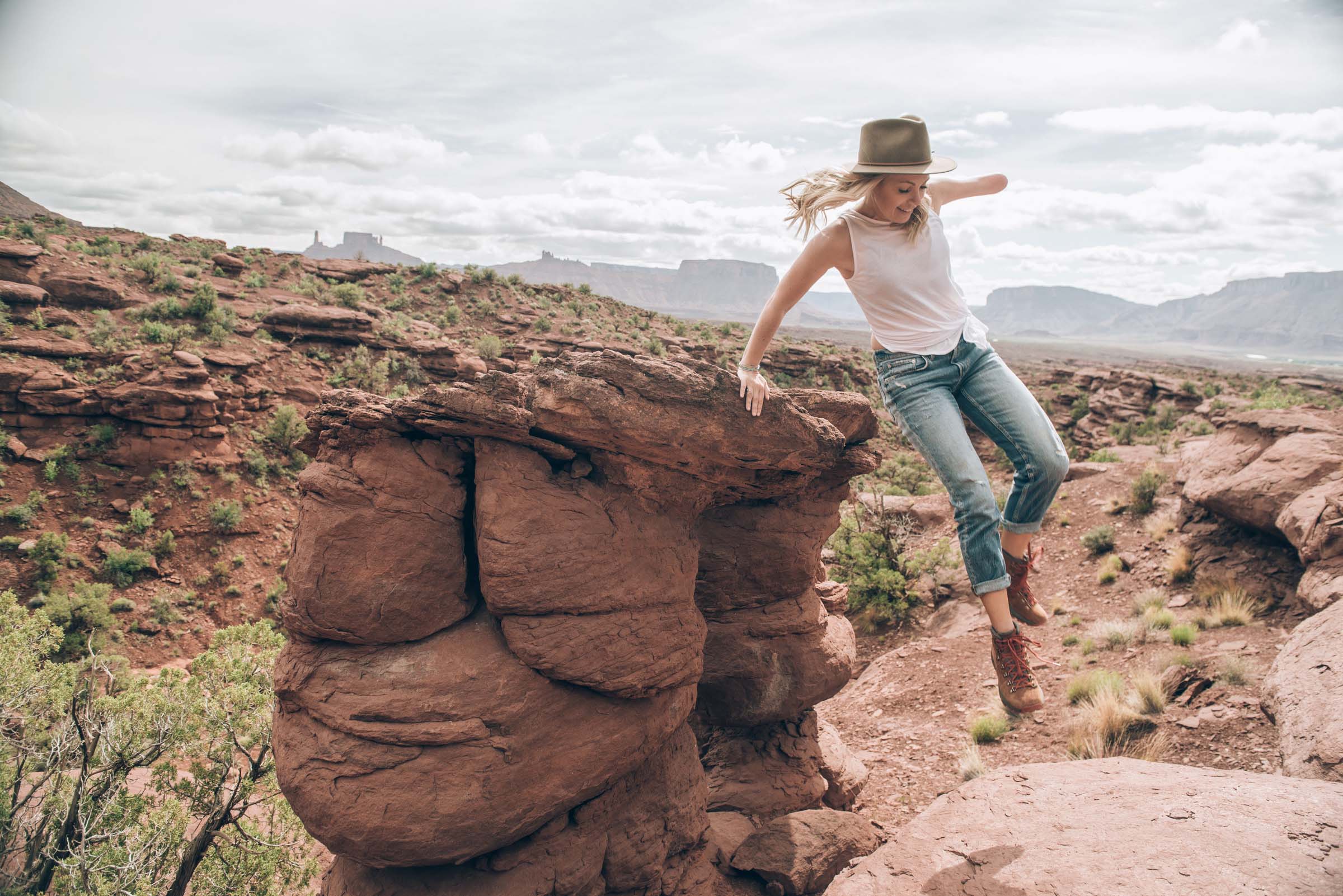 Sarah Herron jumps off a rock at Fisher Towers, Moab