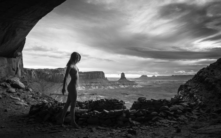 A nude woman tiptoes around the false kiva in canyonlands national park