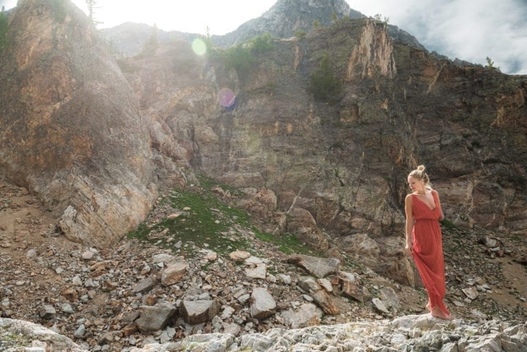 Fashion photographer Dylan H Brown photographs a woman in a red dress in front of a large cliff