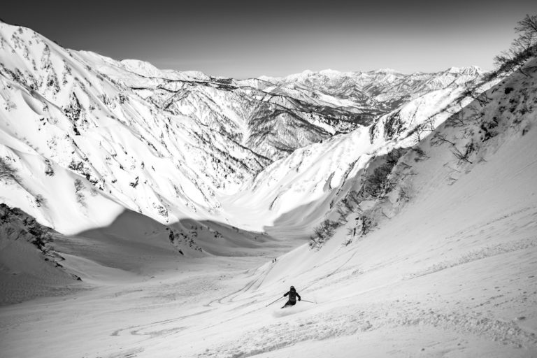 A woman skis into a culiour in the Japanes Alps
