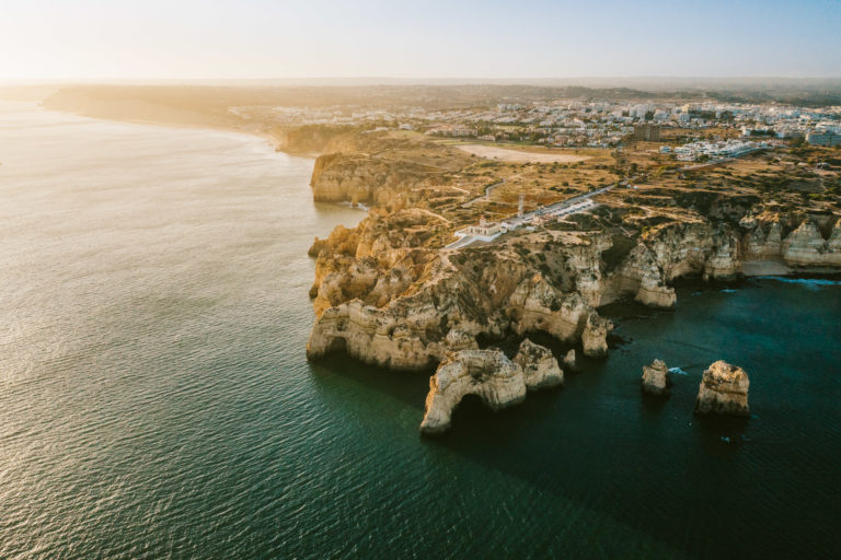 A drone shot shows the Algarve coast at Lagos