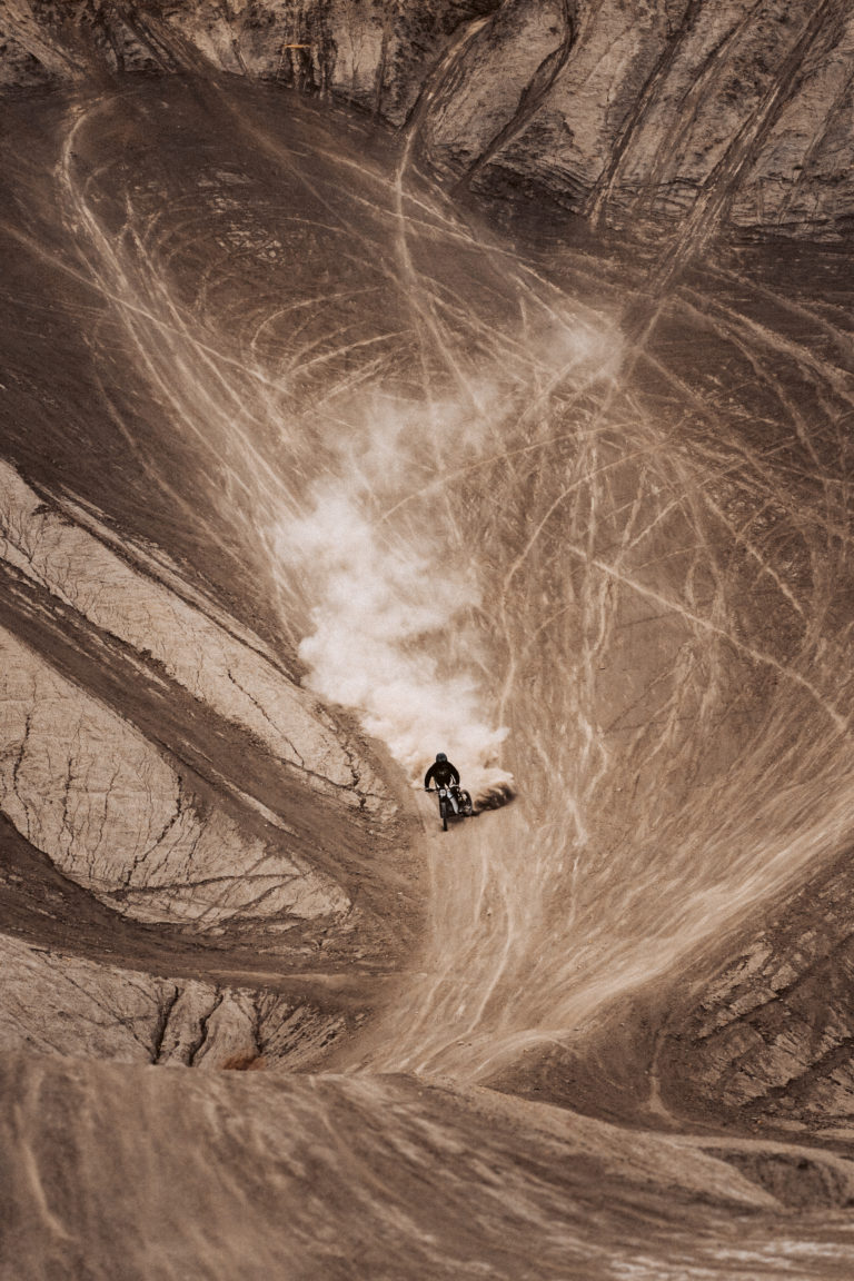 A dirt biker rides a Terra Bike down a dirt hill near Grand Junction.