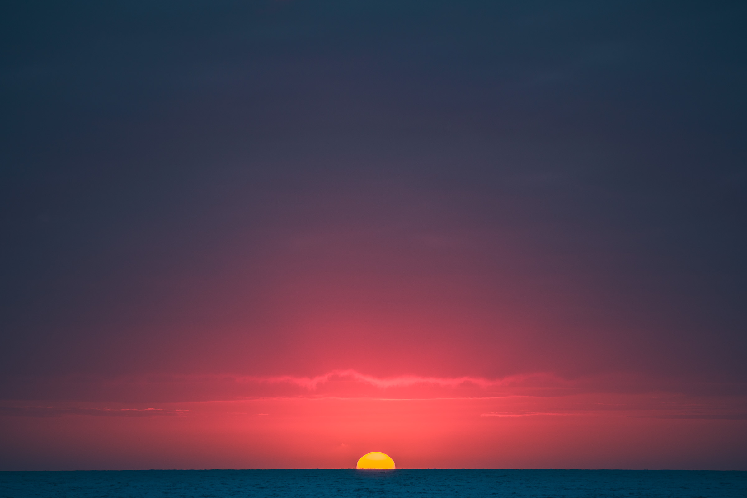 The sun sets on the ocean in Todos Santos, Mexico
