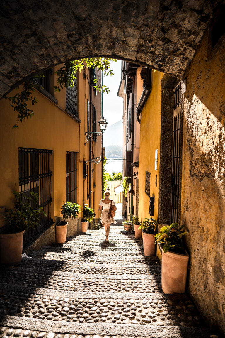 A woman walks down the steps of Varenna, Italy