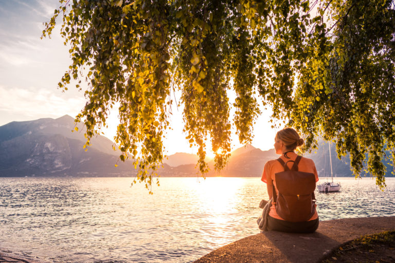 A woman watches the sunset on Lake Como, Italy