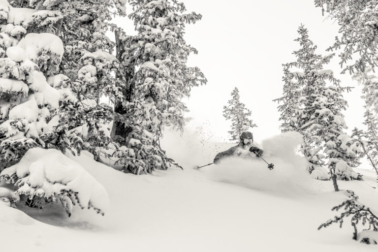 A skier rips through waist deep powder in Highlands Bowl, Aspen, Colorado