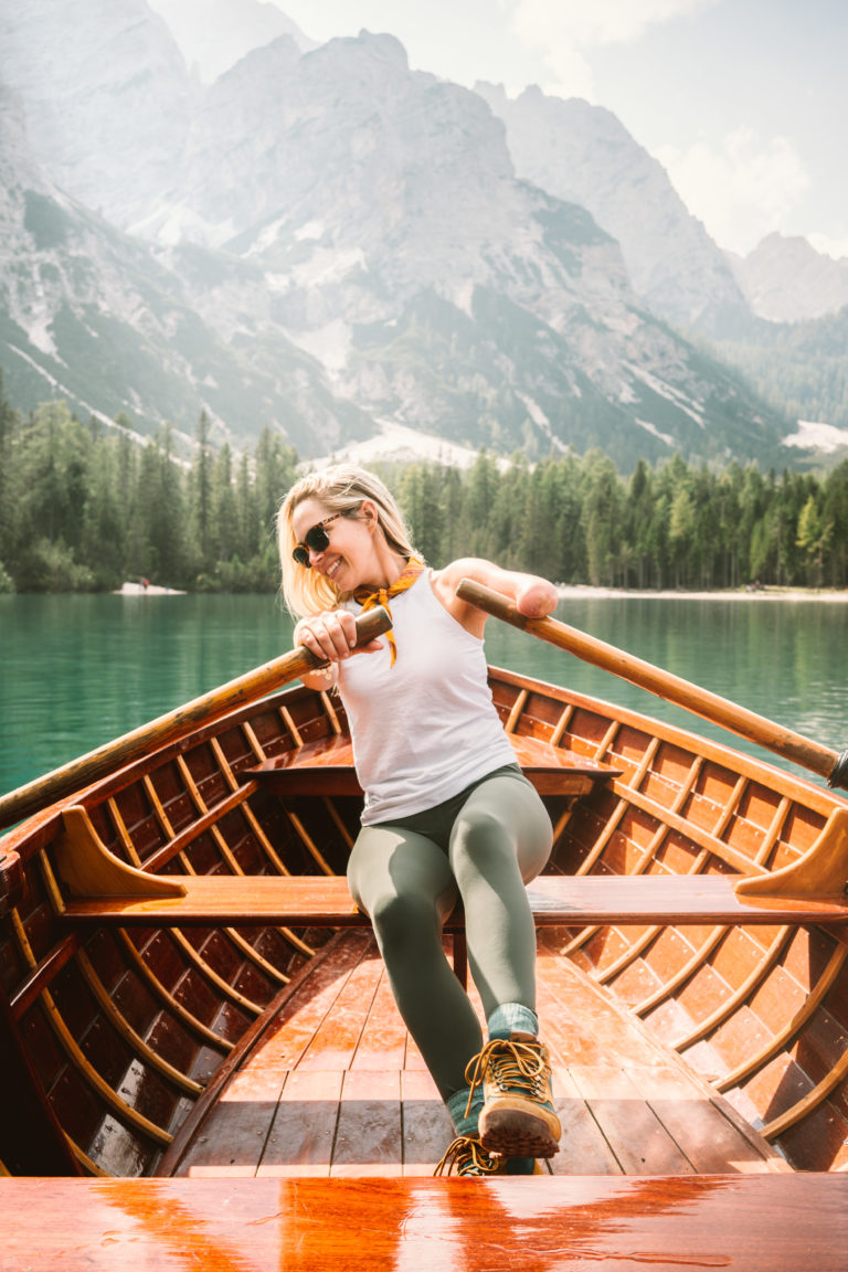 Woman rows a boat in Pragser Wildsee, Italy.