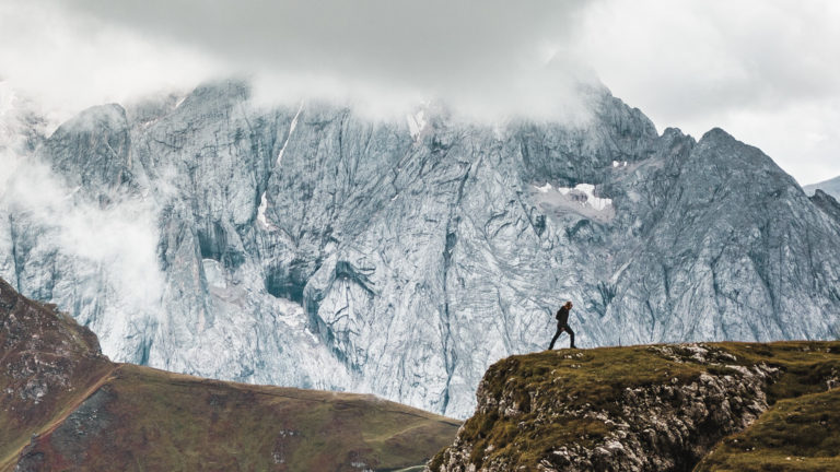 A man walks on a ridge in the Dolomites
