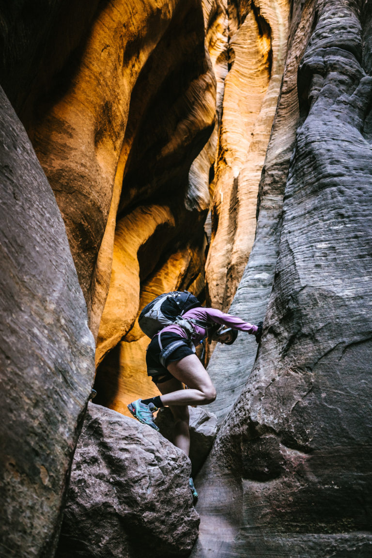 A woman downclimbs in Mystery Canyon in Zion National Park.