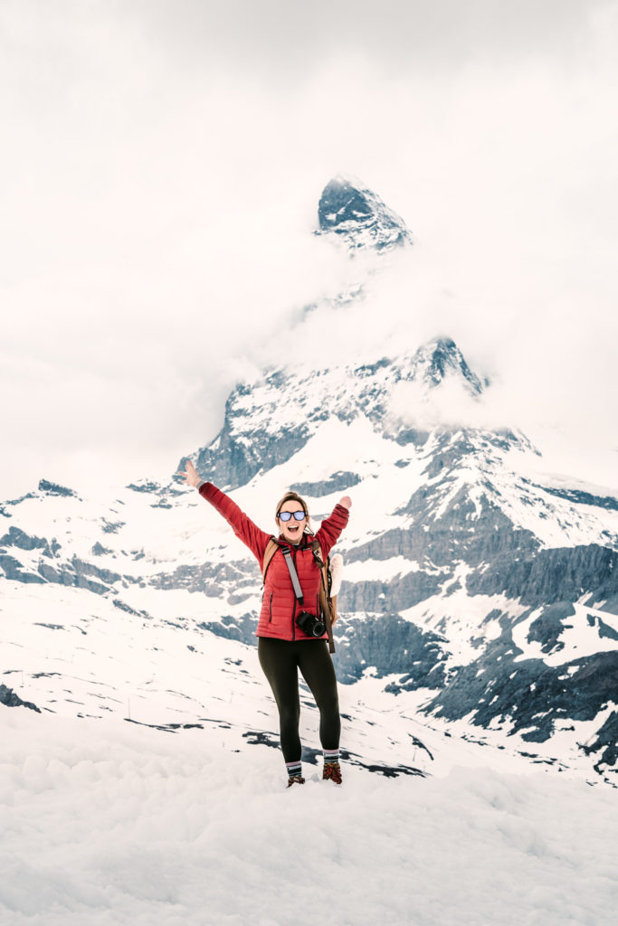 A woman poses in front of the Matterhorn.