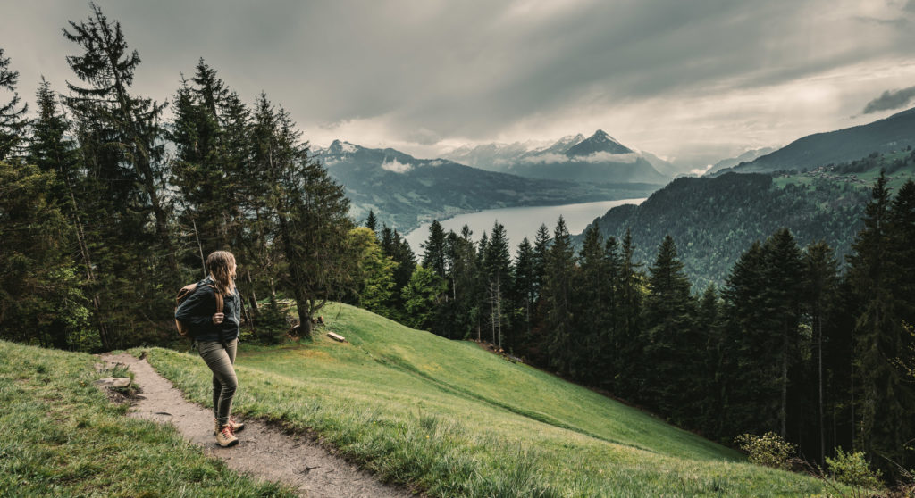 A woman looks back at Interloken while on hike toward Harder Kulm.