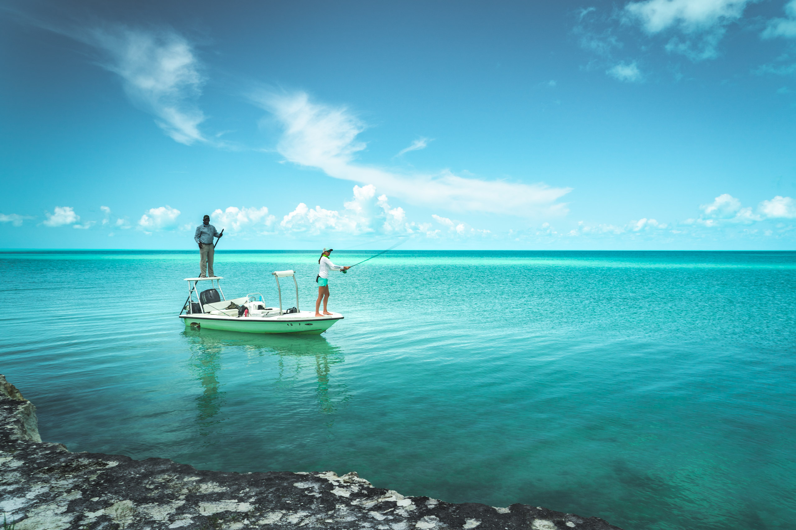 A woman casts for Bone Fish in the Bahamas off Andros Island